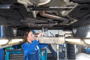 women performing calibration services to the underneath of a car