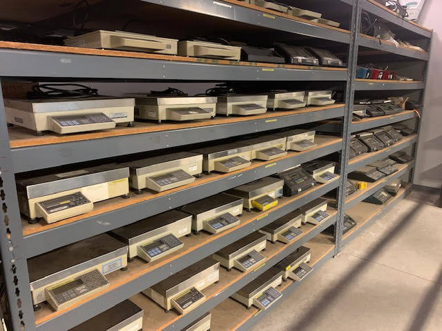 Inventory of scales sitting on a storage shelf.